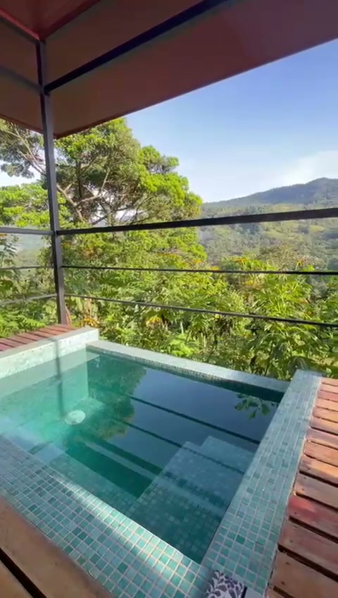 Jacuzzi privado en el balcón de una cabaña, frente a la montaña