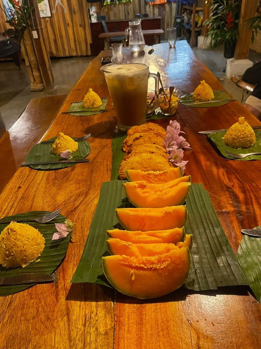 Mesa larga servida con platos de la finca sobre hojas de banano